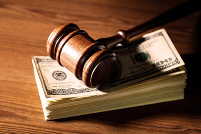 Gavel laying on top of stack of $100 bills. [Image © BillionPhotos.com - Fotolia.com]